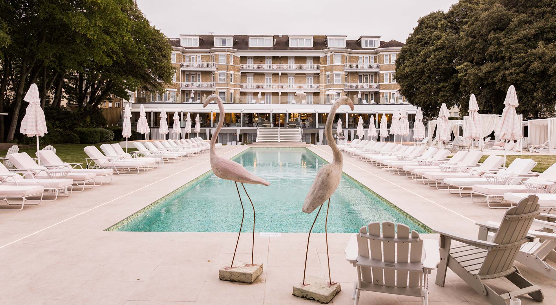 The Nici Hotel, outdoor pool with sun loungers and flamingo sculptures