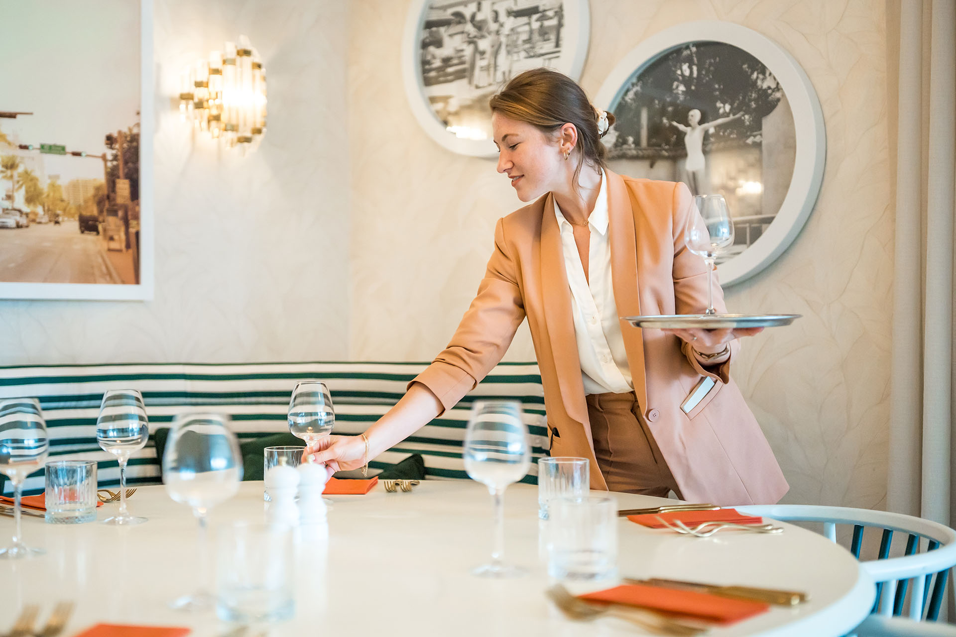 Waitress placing glass onto a table in a stylish restaurant
